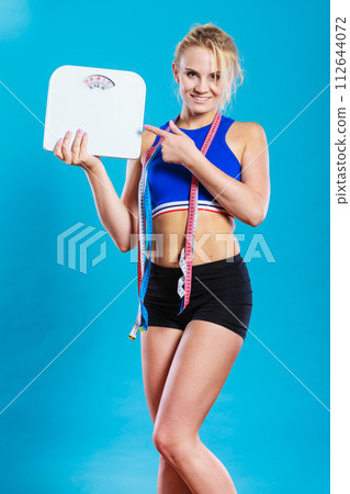 Fit woman with measure tape with weight scale Fit woman with measure tape with weight scale 112644072