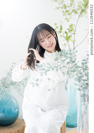 A beauty image of a young woman's flowing hair with organic and natural greenery, a hair care image A beauty image of a young woman's flowing hair with organic and natural greenery, a hair care image 112646032