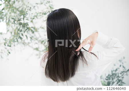 A bird's-eye view of the beauty of a young woman's waving hair with an organic and natural image of greenery - a hair care image 112646040