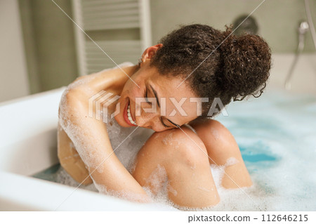 Happy woman in bathtub, smiling while bathing, barechested, leisure gesture Happy woman in bathtub, smiling while bathing, barechested, leisure gesture 112646215