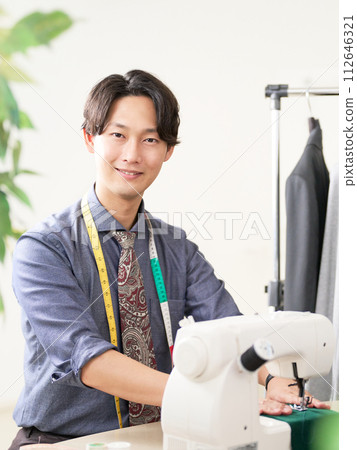 使用縫紉機的年輕男性時裝設計師 112646321