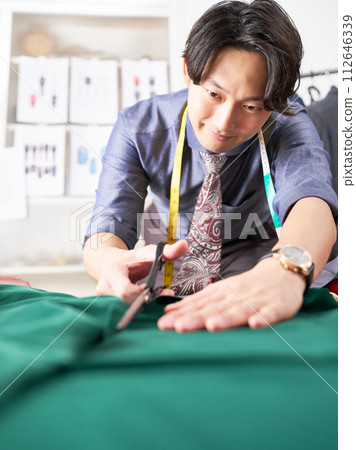 Young fashion designer using scissors 112646339