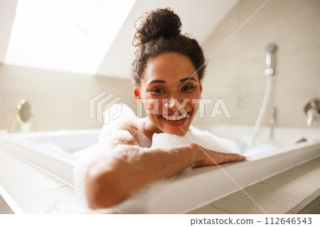 The woman is happily bathing in a jacuzzi tub, smiling with joy 112646543