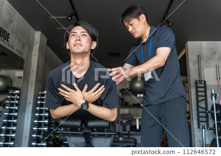 年輕的亞洲男子在體育館接受個人訓練 年輕的亞洲男子在體育館接受個人訓練 112646572