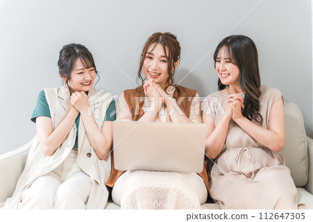 Women, friends, mom friends, and colleagues using laptops at home with friends Women, friends, mom friends, and colleagues using laptops at home with friends 112647305