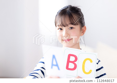 Girl holding English alphabet cards 112648017