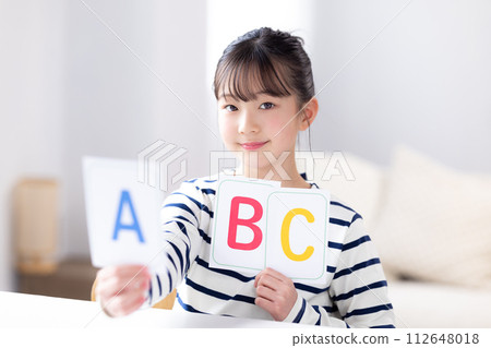 Girl holding English alphabet cards 112648018