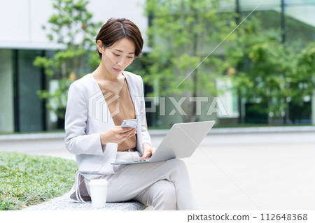Business woman operating a smartphone Business woman operating a smartphone 112648368