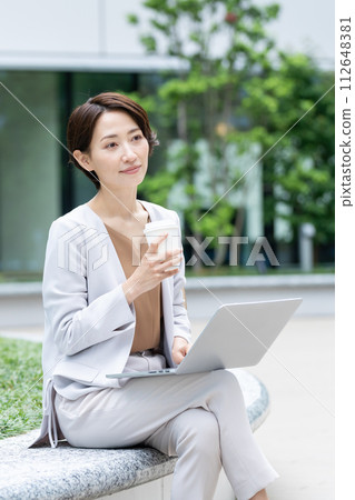 Business woman looking at computer while drinking coffee 112648381