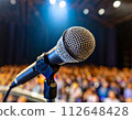 一支麥克風站在燈光照亮的舞台上 112648428