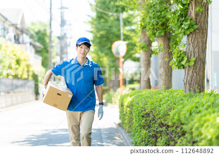 A courier male driver delivering a package A courier male driver delivering a package 112648892