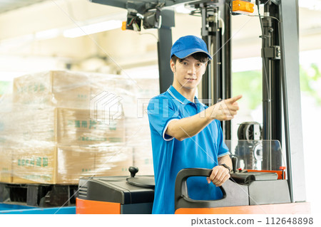 一個人在倉庫裡駕駛叉車 112648898