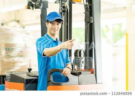 一個人在倉庫裡駕駛叉車 112648899