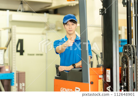 一個人在倉庫裡駕駛叉車 112648901