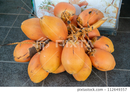 Group of king coconut (known as Thembili) in local market of Sri Lanka. Coconut is one of the major plantation crops in Sri Lanka there are found commonly growing wild in many areas of the country. Group of king coconut (known as Thembili) in local market of Sri Lanka. Coconut is one of the major plantation crops in Sri Lanka there are found commonly growing wild in many areas of the country. 112649357