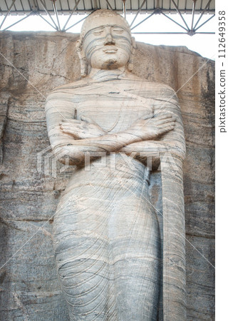 The standing image depicts an unusual mudra is said to be the finest of the series at Gal Vihara in ancient city of Polonnaruwa, Sri Lanka. The standing image depicts an unusual mudra is said to be the finest of the series at Gal Vihara in ancient city of Polonnaruwa, Sri Lanka. 112649358
