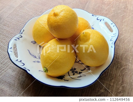 Domestic lemons served on Western tableware on the table 112649456