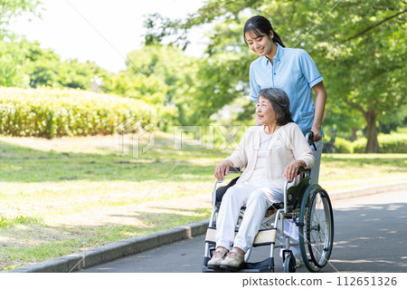 Senior woman in wheelchair and young woman caregiver 112651326