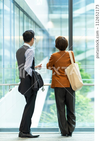 Businesswoman and businessman talking in the office Businesswoman and businessman talking in the office 112652173