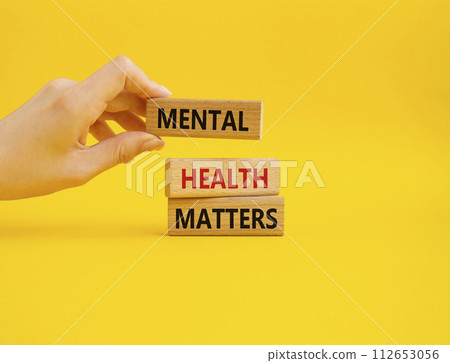 Mental Health Matters symbol. Concept words Mental Health Matters on wooden blocks. Beautiful yellow background. Doctor hand. Healthcare and Mental Health Matters concept. Copy space. 112653056