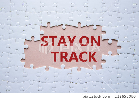 Stay on track symbol. Concept words Stay on track on white puzzle. Beautiful pink background. Business and Stay on track concept. Copy space. Stay on track symbol. Concept words Stay on track on white puzzle. Beautiful pink background. Business and Stay on track concept. Copy space. 112653096