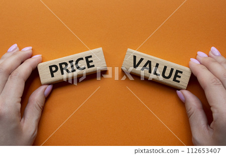 Price and Value symbol. Concept word Price and Value on wooden blocks. Businessman hand. Beautiful orange background. Business and Price and Value concept. Copy space Price and Value symbol. Concept word Price and Value on wooden blocks. Businessman hand. Beautiful orange background. Business and Price and Value concept. Copy space 112653407