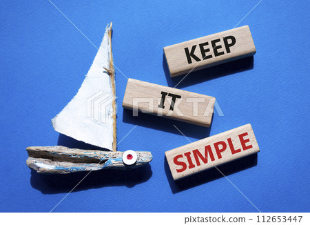 Keep it Simple symbol. Concept words Keep it Simple on wooden blocks. Beautiful blue background with boat. Business and Keep it Simple concept. Copy space. Keep it Simple symbol. Concept words Keep it Simple on wooden blocks. Beautiful blue background with boat. Business and Keep it Simple concept. Copy space. 112653447