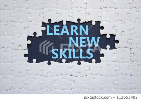 Learn new skills symbol. Concept words Learn new skills on white puzzle. Beautiful deep blue background. Business and Learn new skills concept. Copy space. 112653492