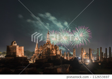 Fireworks celebration of Loy Krathong at Sukhothai Historical Park festival, buddha pagoda stupa in a temple, Sukhothai, Thailand. Thai buddhist temple architecture at night. Tourist attraction. 112653697