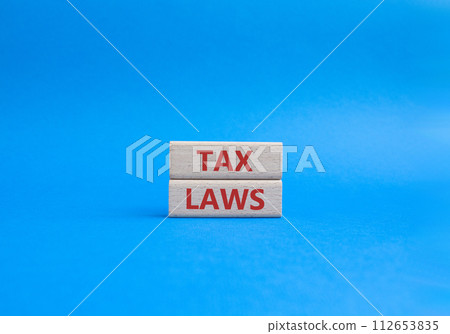 Tax Laws symbol. Concept word Tax Laws on wooden blocks. Beautiful blue background. Business and Tax Laws concept. Copy space 112653835