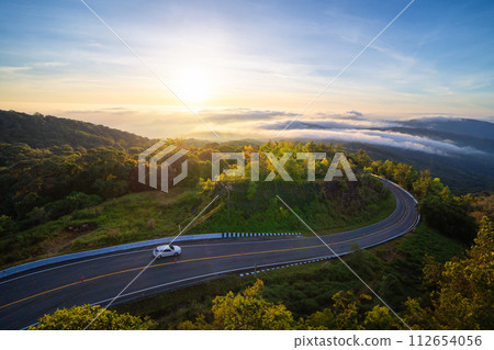 Aerial view of national park Inthanon, cars driving on curved, zigzag curve road or street on mountain hill with green natural forest trees in rural area of Chiang Mai, Thailand. 112654056
