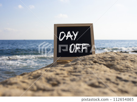 Day off symbol. Day off black chalk blackboard. Beautiful sea background. Business and Day off concept. Copy space. 112654865