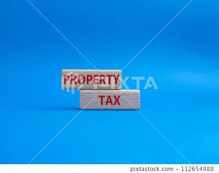 Property Tax symbol. Concept word Property Tax on wooden blocks. Beautiful blue background. Business and Property Tax concept. Copy space 112654888