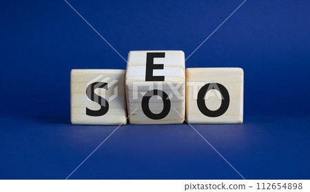 SEO vs SOO symbol. Wooden cubes with words SOO and SEO. Beautiful deep blue background. SEO vs SOO and business concept. Copy space 112654898