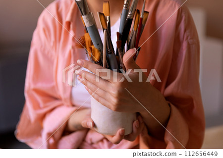 paint brushes on a hand made clay vase at clay workshop paint brushes on a hand made clay vase at clay workshop 112656449
