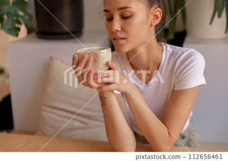 A girl with hand made mug sitting at table A girl with hand made mug sitting at table 112656461