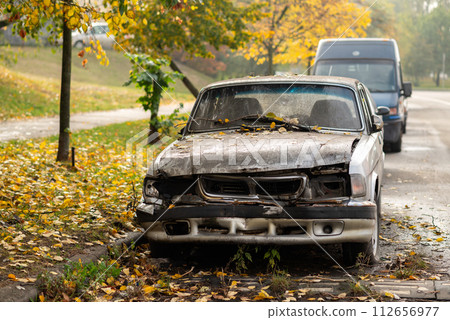a broken down abandoned old car near road 112656977