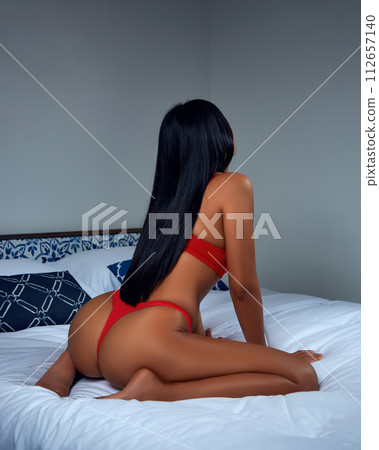 Sexy asian girl in red lingerie sitting on the bed 112657140