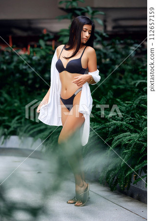 Young asian sexy girl in a white bikini posing at hotel territory Young asian sexy girl in a white bikini posing at hotel territory 112657159