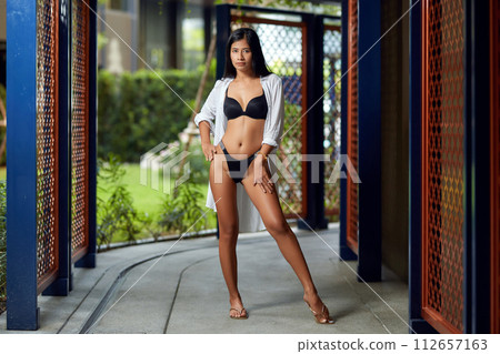 Young asian sexy girl in a white bikini posing at hotel territory Young asian sexy girl in a white bikini posing at hotel territory 112657163