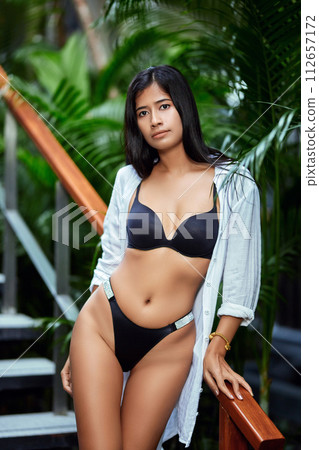 Young asian sexy girl in a white bikini posing at hotel territory Young asian sexy girl in a white bikini posing at hotel territory 112657172