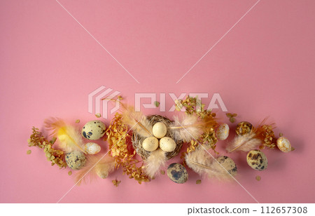 Easter composition with quail eggs, feathers, and dried flowers. 112657308