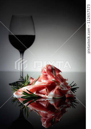Italian prosciutto or Spanish jamon with rosemary and red wine. 112657573