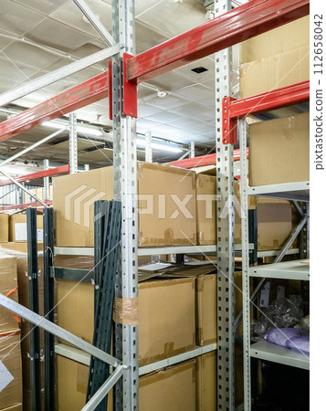 cardboard boxes on racks in warehouse 112658042