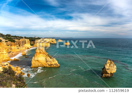 Natural caves and beach, Algarve Portugal. Rock cliff arches of Seven Hanging Valleys and turquoise sea water on coast of Portugal in Algarve region 112659619
