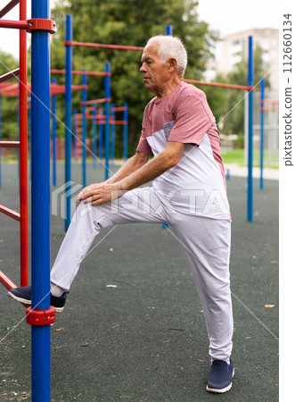 Elderly man pulls himself up outdoors Elderly man pulls himself up outdoors 112660134