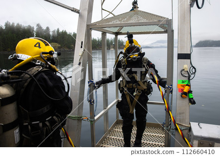 Commercial divers entering deep water for work Commercial divers entering deep water for work 112660410