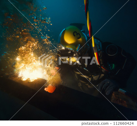 Commercial diver welding underwater at construction site Commercial diver welding underwater at construction site 112660424
