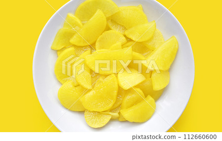 Sweet and tart slices of yellow pickled daikon, known as takuan in Japan and danmuji in Korea. 112660600