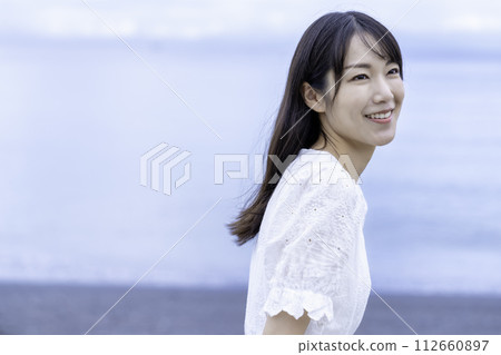 A woman strolling by the sea 112660897